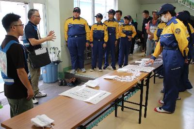 避難生活施設運営委員会から受付の方法を学ぶ少年消防団員