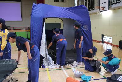 避難所で就寝スペースを設営する少年消防団員